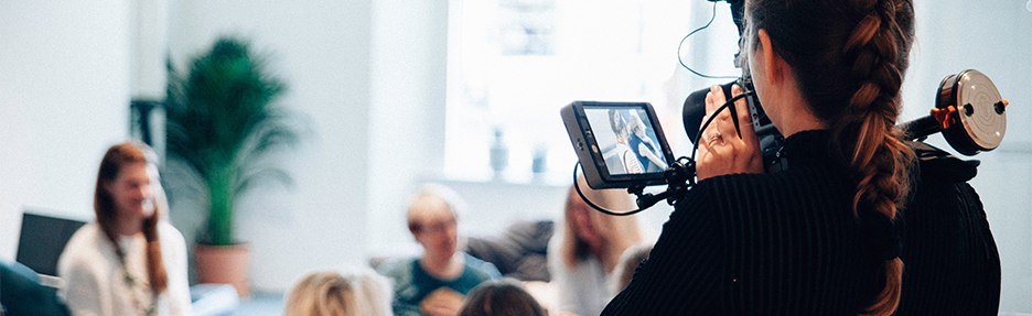 A woman recording a meeting with a video camera
