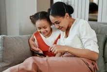 Woman and child looking at a cell phone and smiling